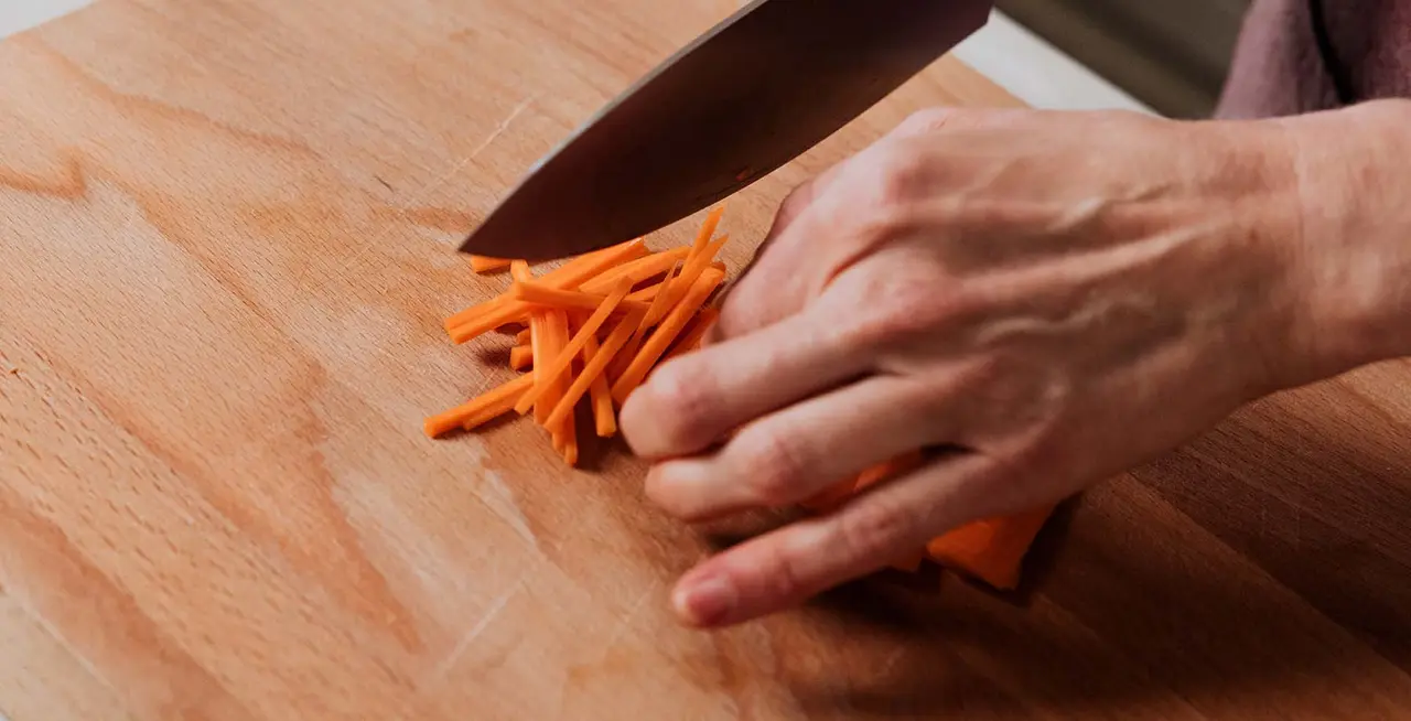Cutting carrot in brunoise dice. Chef cooking. Types of cuts. Stock Photo