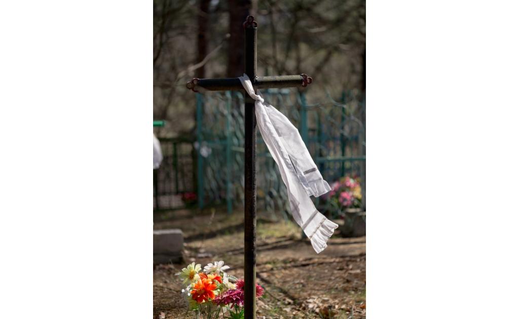 Cross with a white scarf in a cemetery