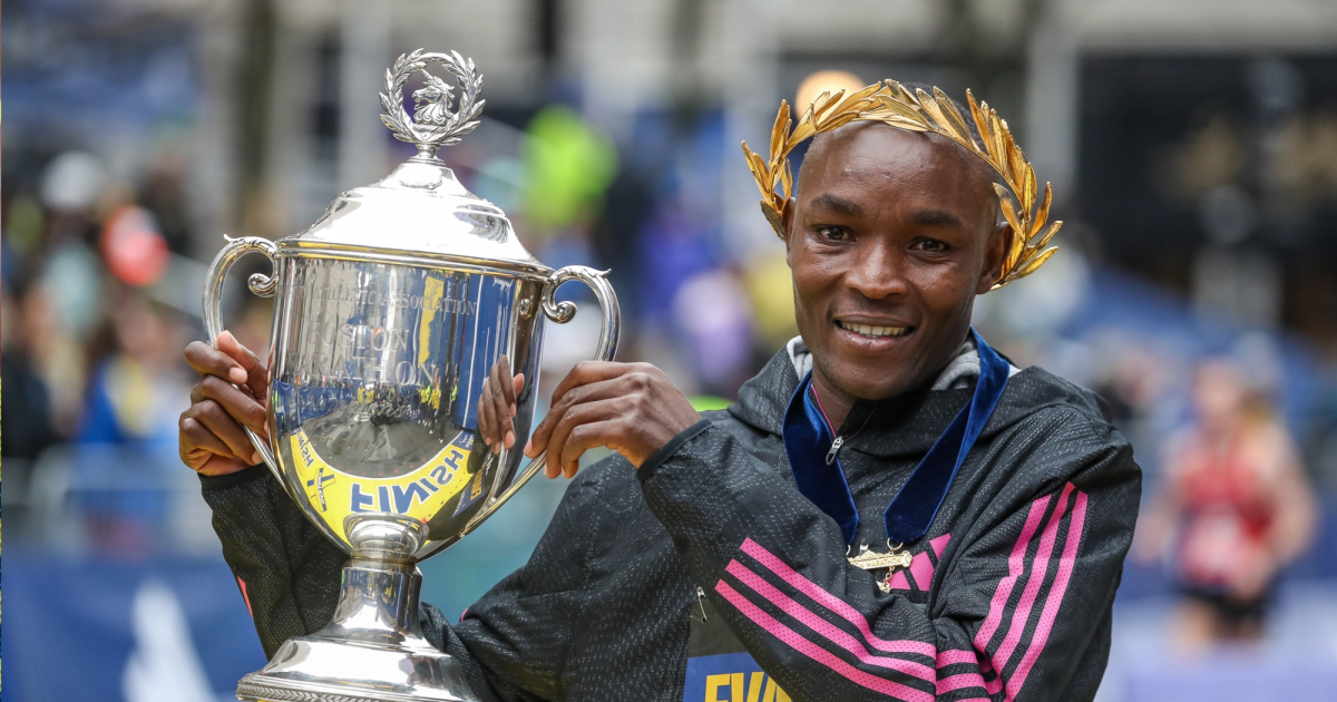 Kenya's Evans Chebet raises the champion's trophy after the 2023 Boston Marathon.