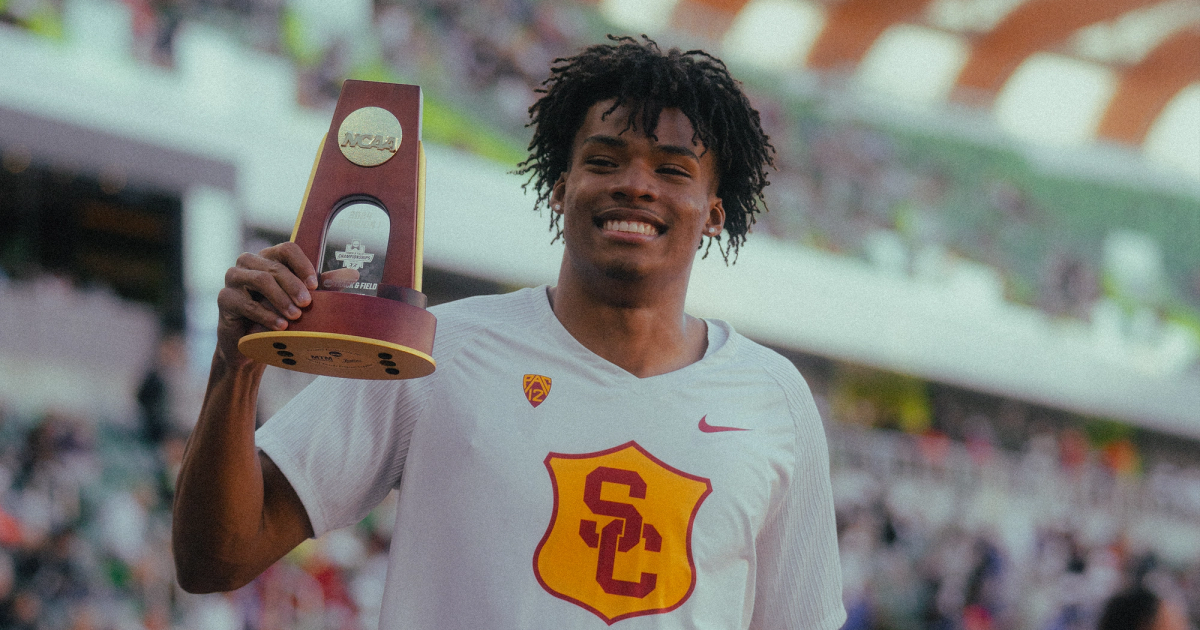 JC Stevenson holding his trophy after winning the NCAA title in the long jump.