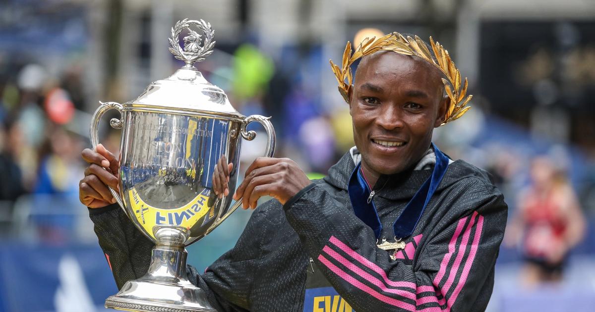 Evans Chebet holds the winner's cup after his victory at the 2023 Boston Marathon.