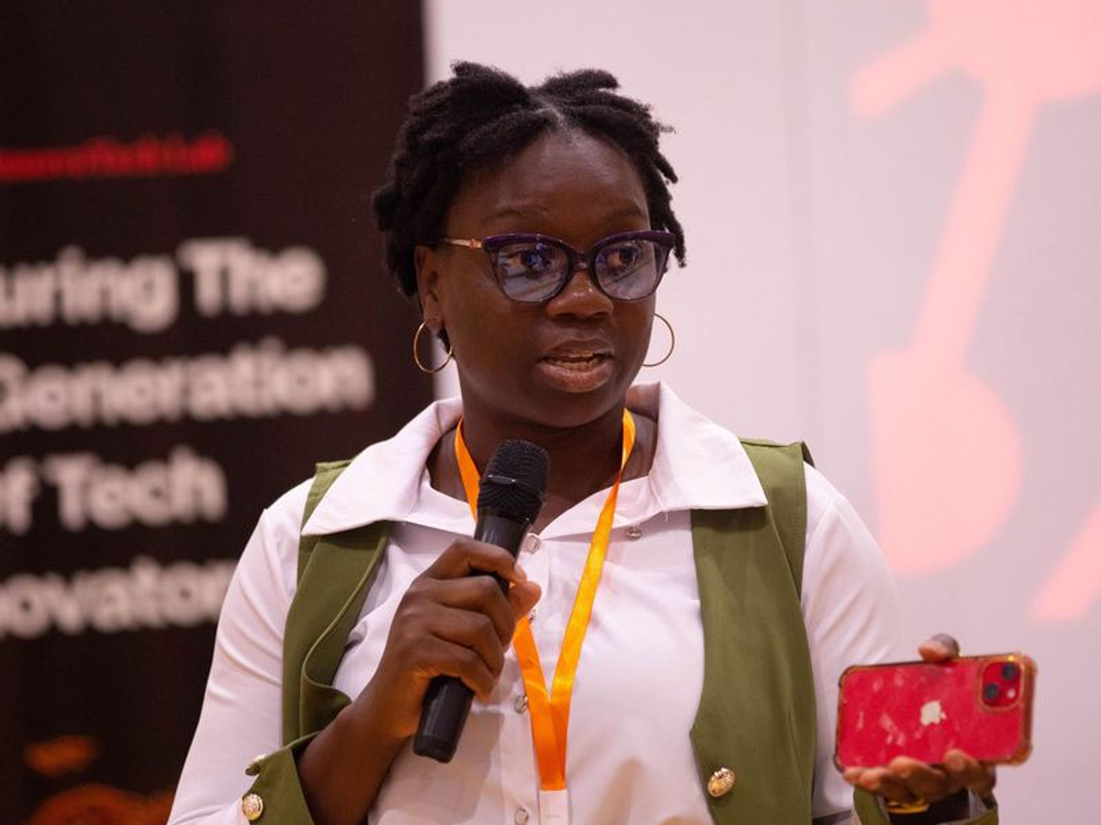 A speaker with a microphone presenting on stage