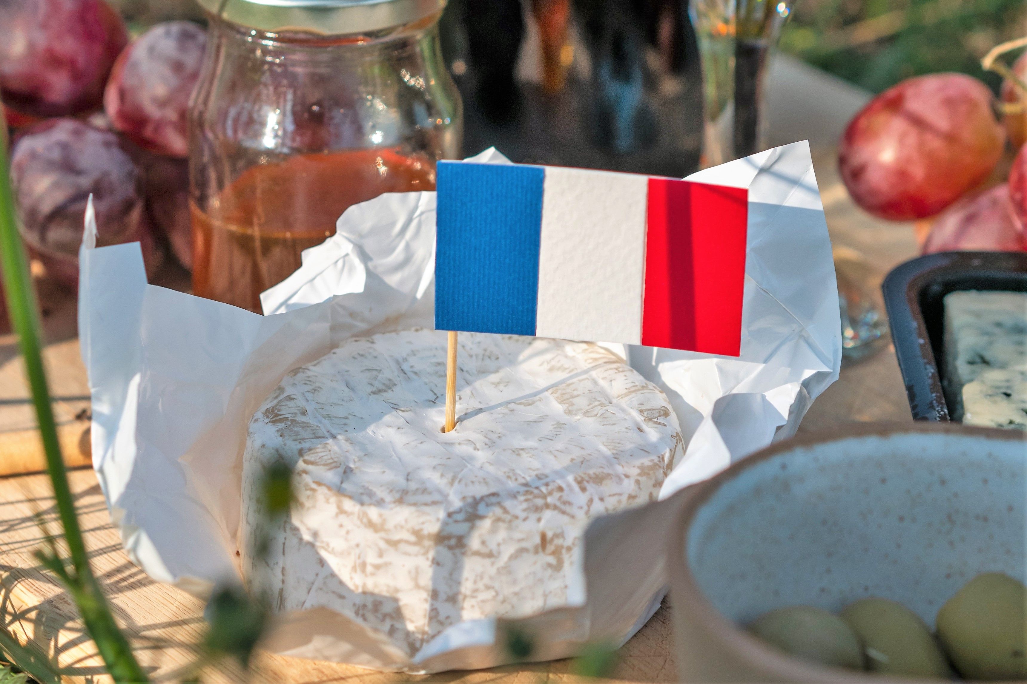 Camembertost i solen, med en fransk flagga på toppen. 
