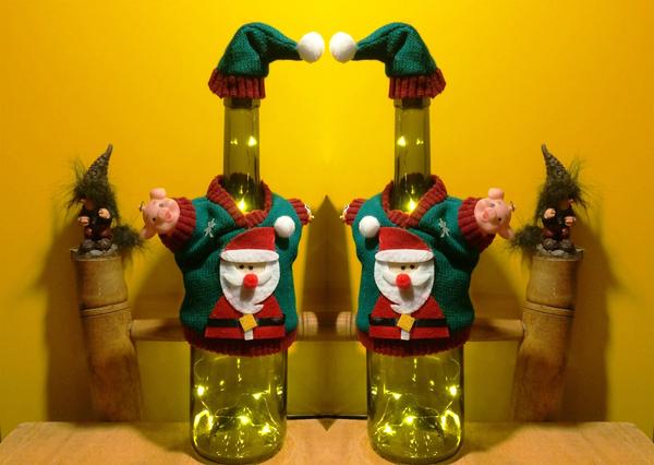 Լուսավորված շշերը ձմեռ պապի շորեր են հագել, թիկունքում փոքրիկ տրոլներ են