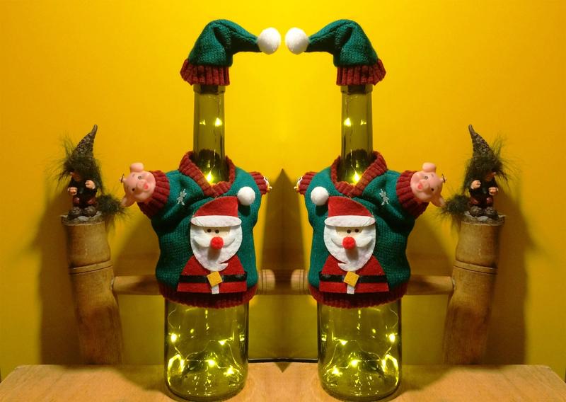 Լուսավորված շշերը ձմեռ պապի շորեր են հագել, թիկունքում փոքրիկ տրոլներ են