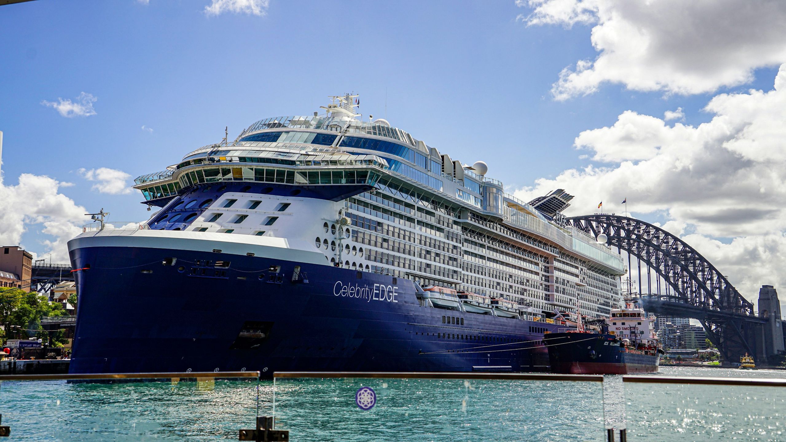 A large cruise ship docked near Sydney Harbour Bridge, Australia