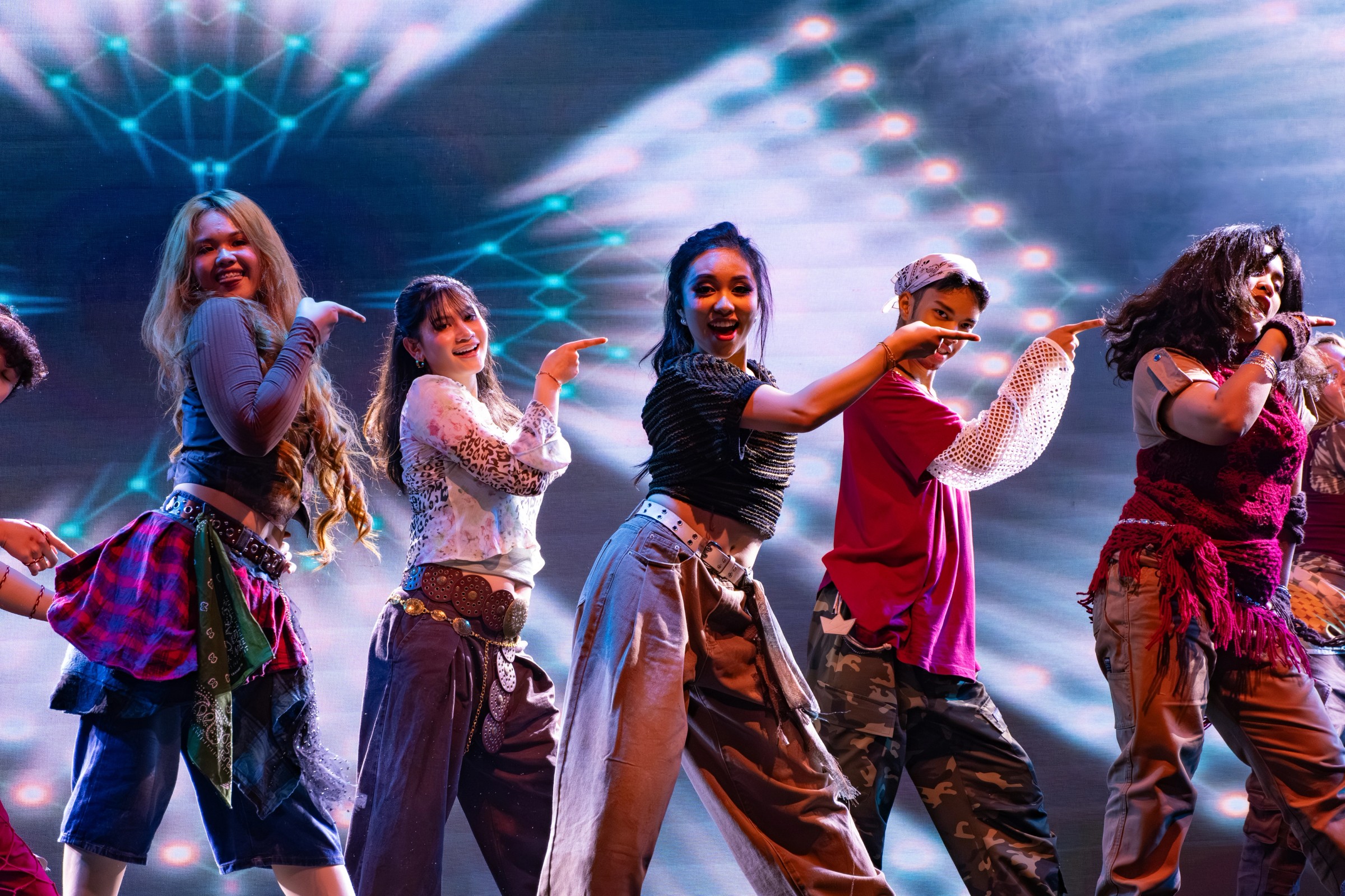 Dancers performing together on stage beneath colourful LED lights and spotlights at Kalayaan 2026.