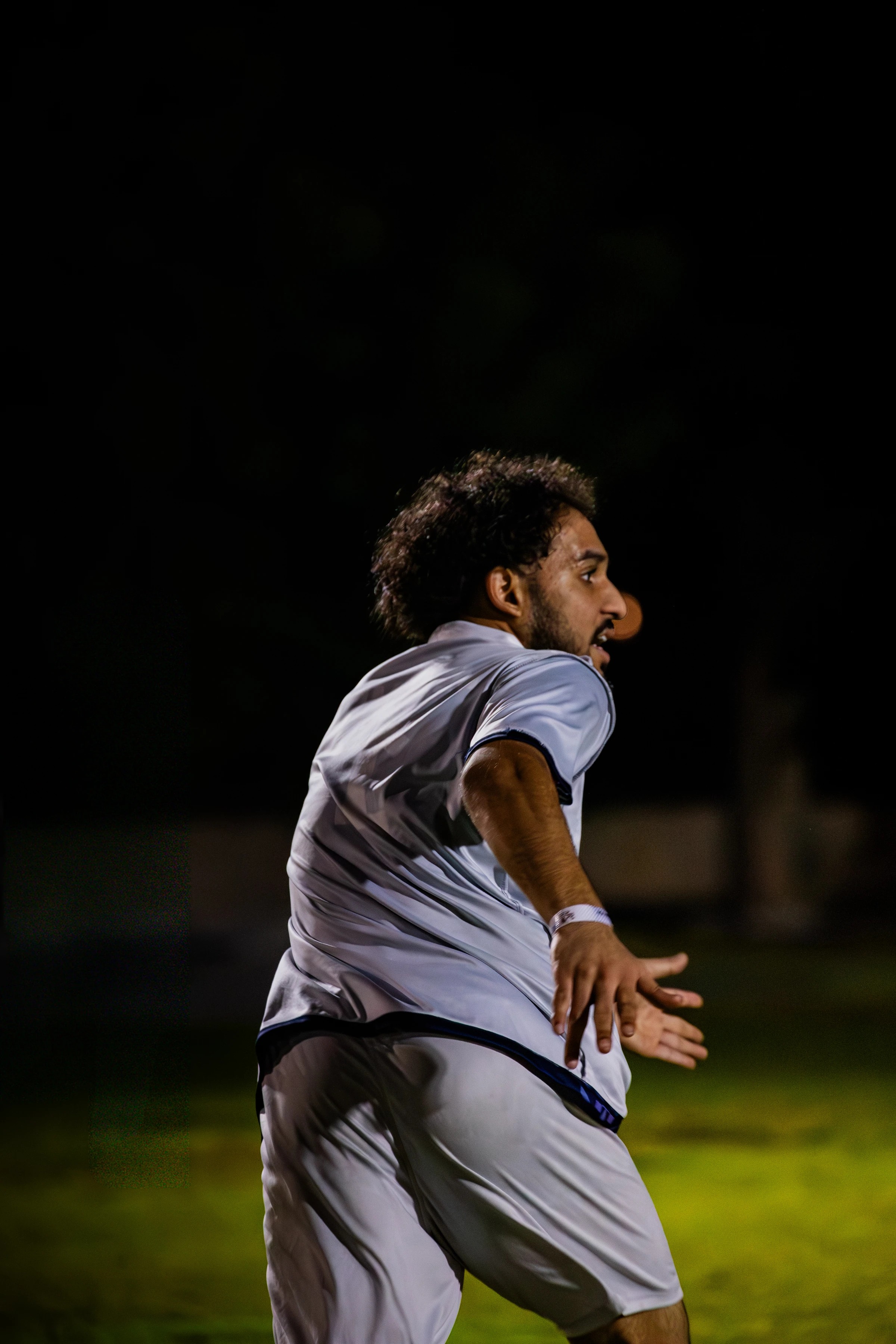 Football player looking across the pitch at night