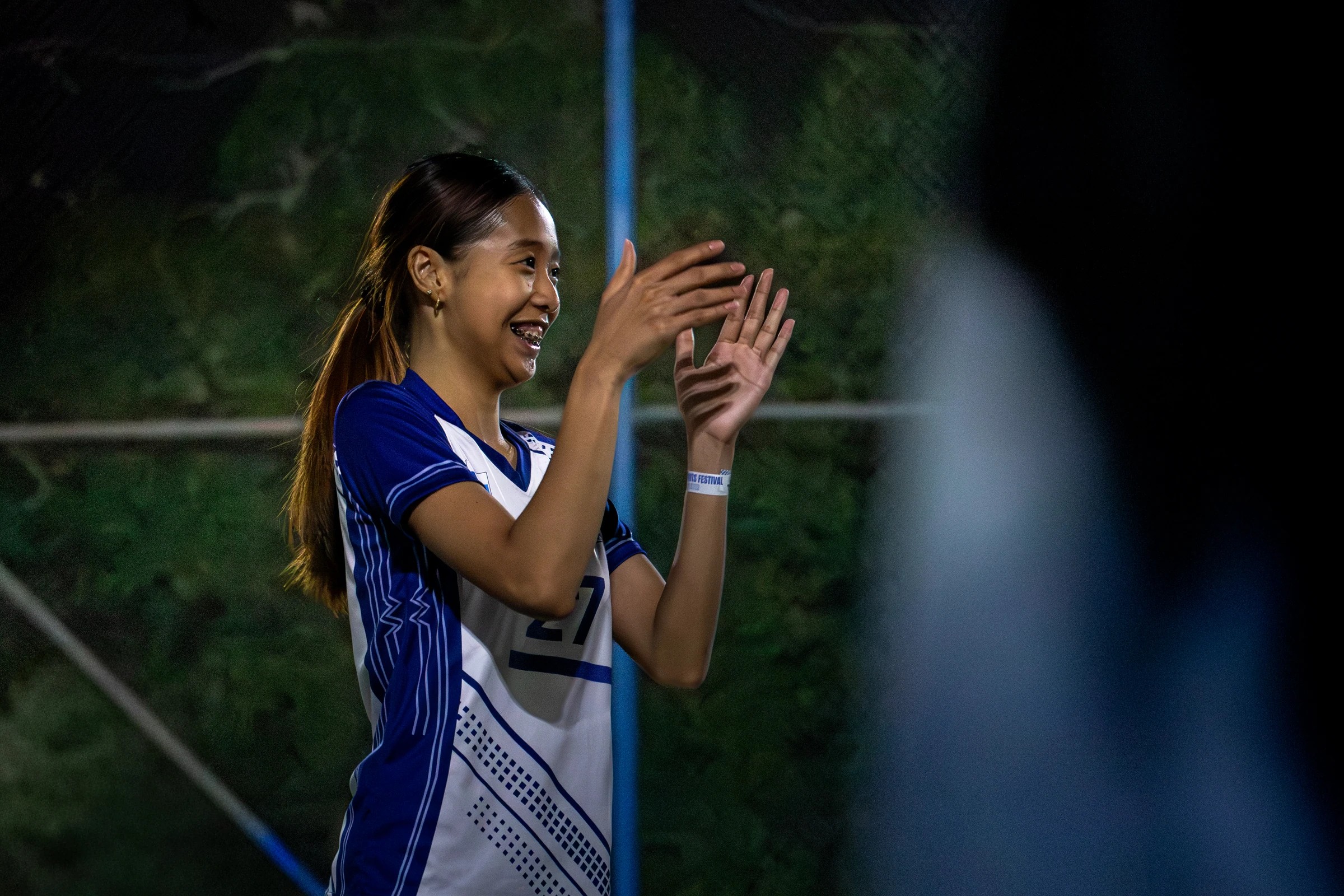 Volleyball player applauding beside the court