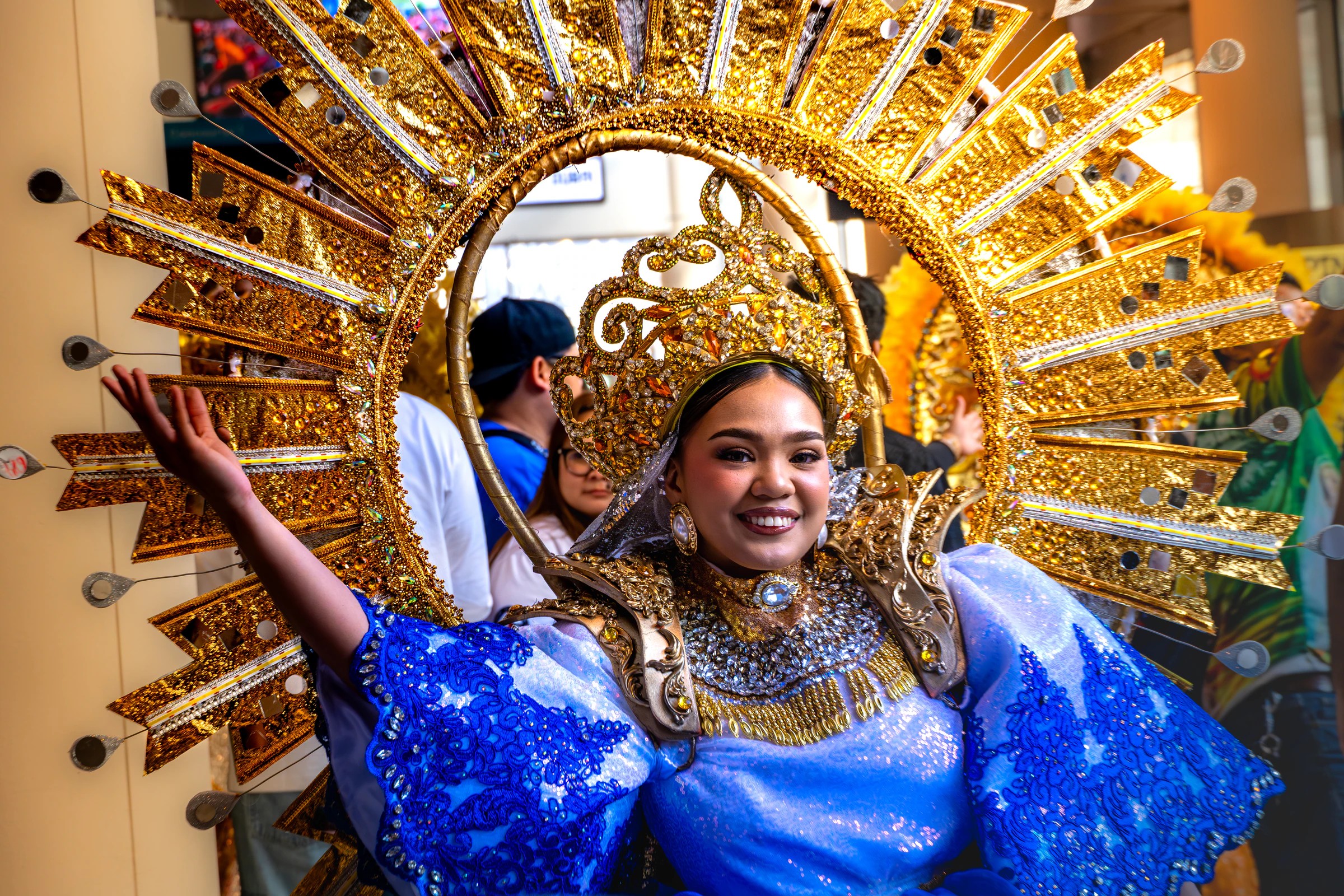 PID participant in a blue costume and gold headdress
