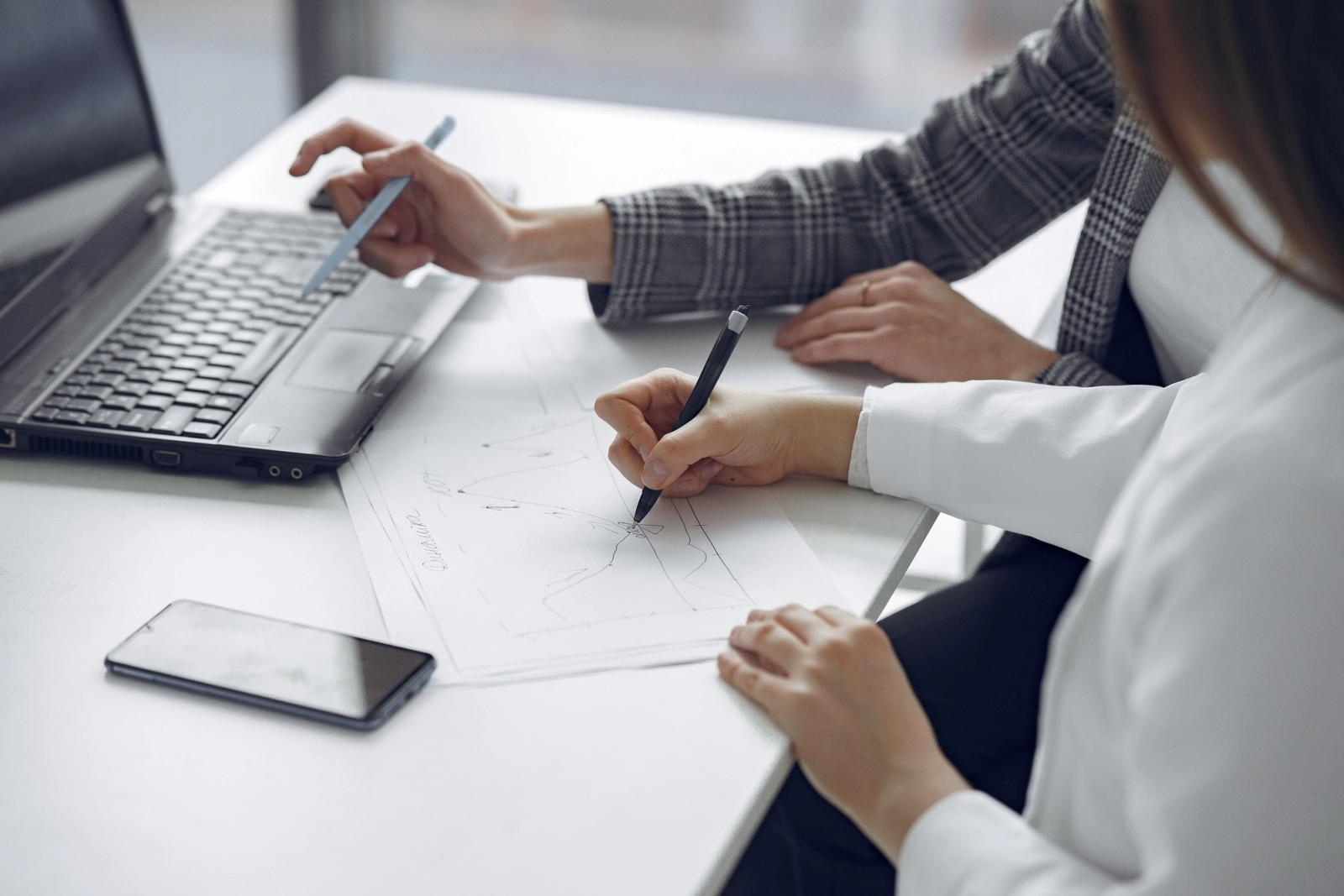 Professionals collaborating around a laptop for CRM planning