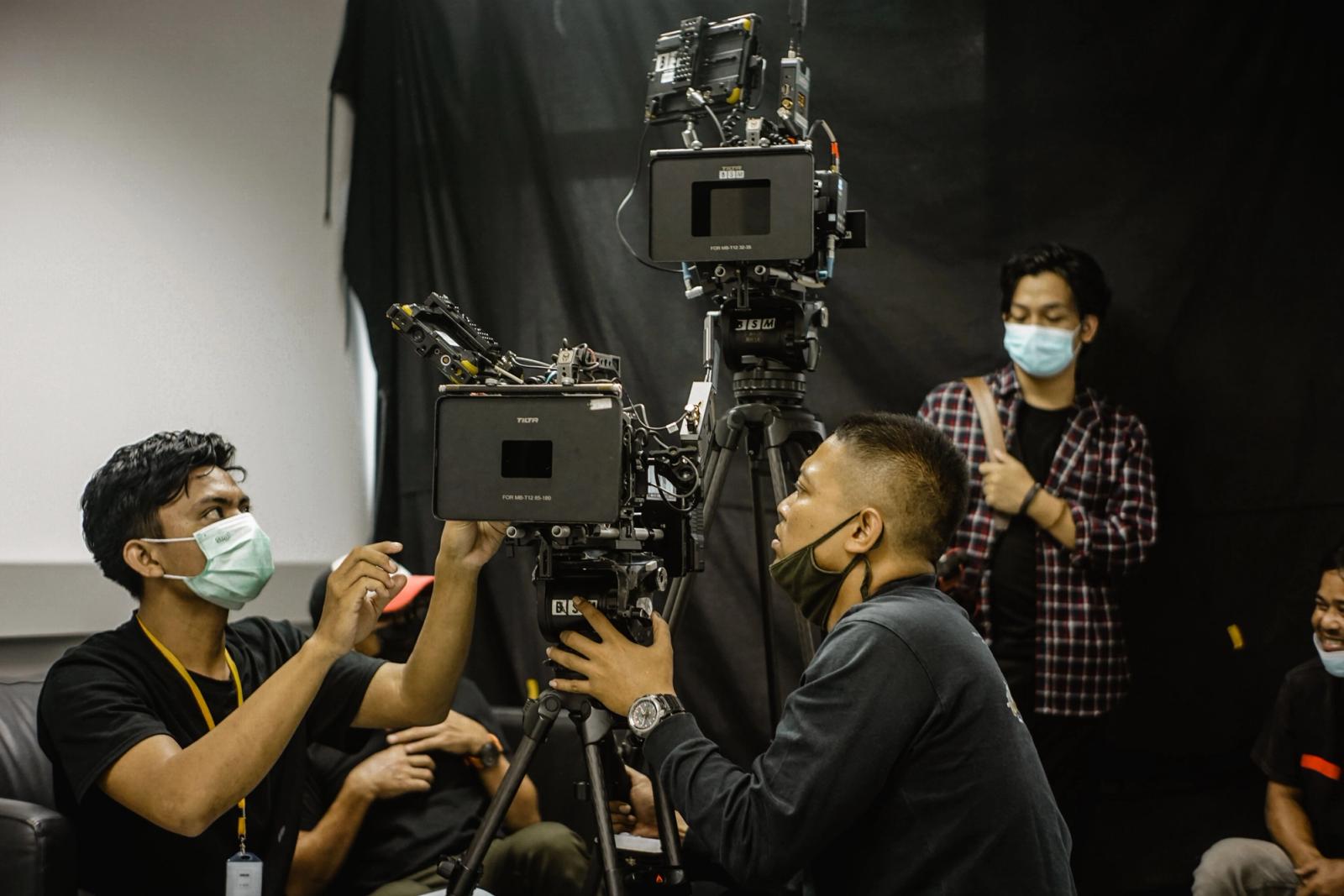 Videographers setting up professional camera equipment