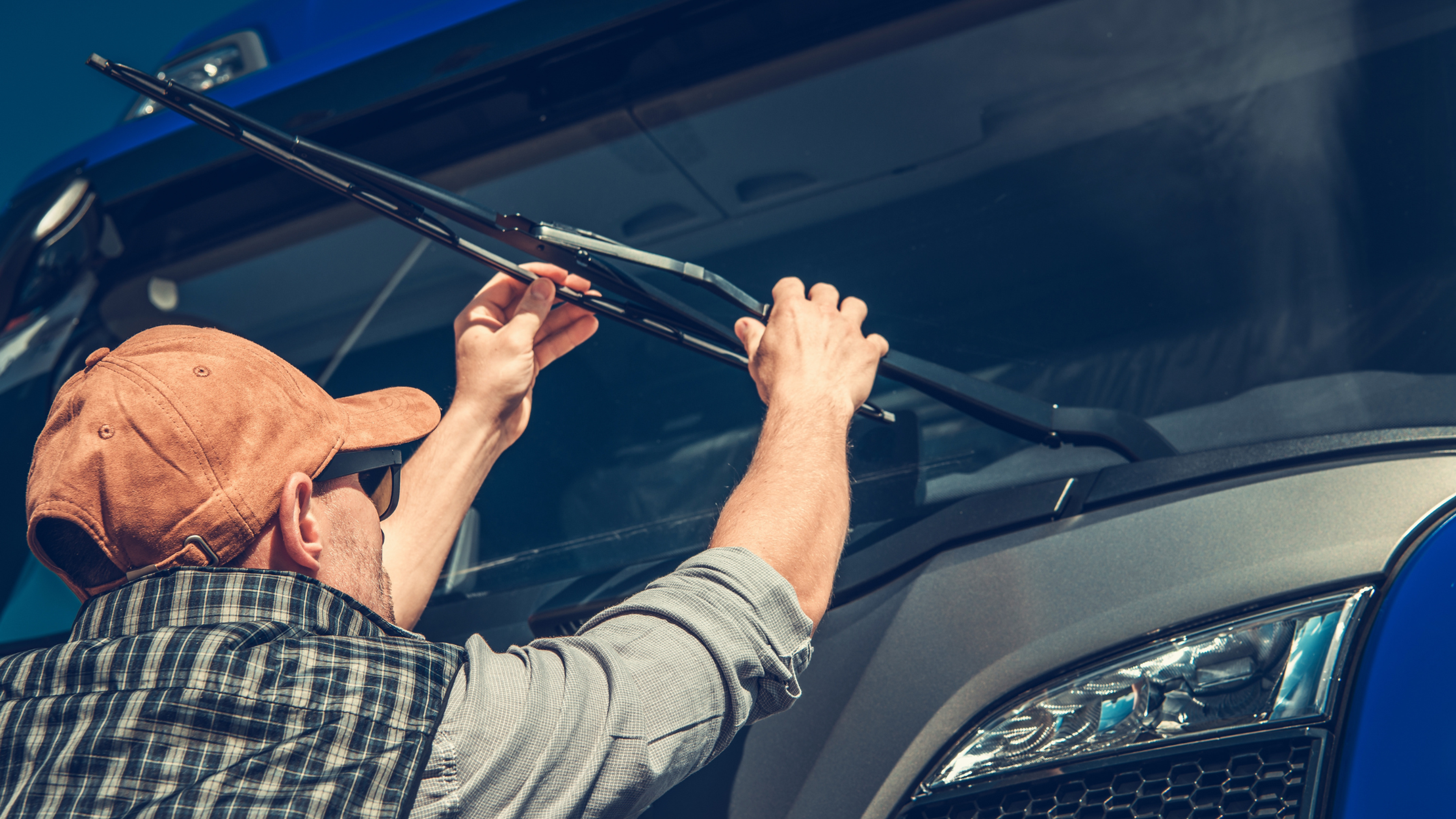 A man replacing windshield wipers on his truck