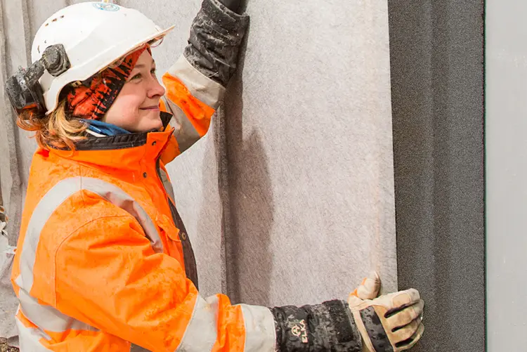 Foto af håndværker i gang med at montere effektiv drænplade i grå EPS