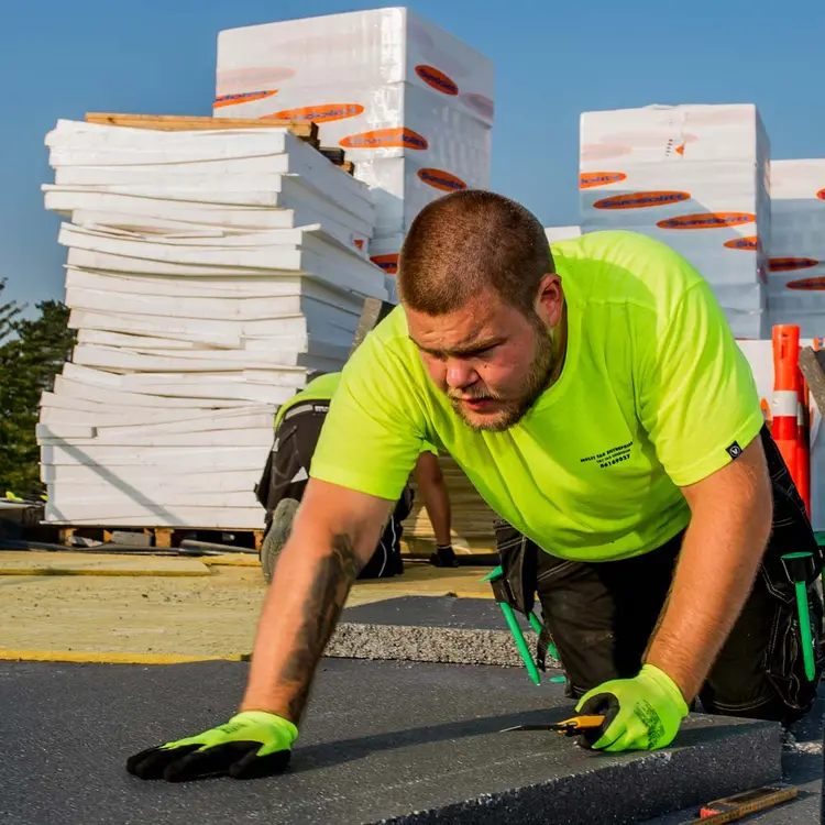 Håndværker i gang med at isolere tagkonstruktion med EPS
