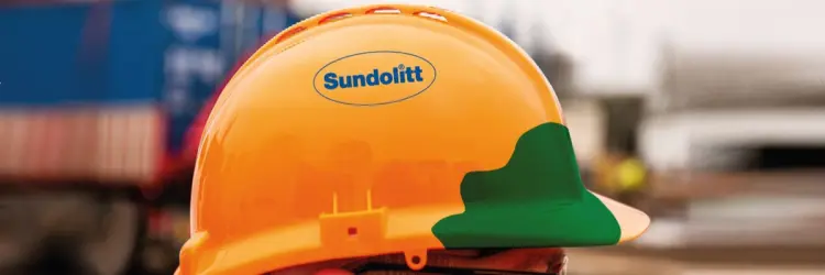 Orange sikkerhedshjelm med Sundolitt logo og en grøn afmærkning på fronten