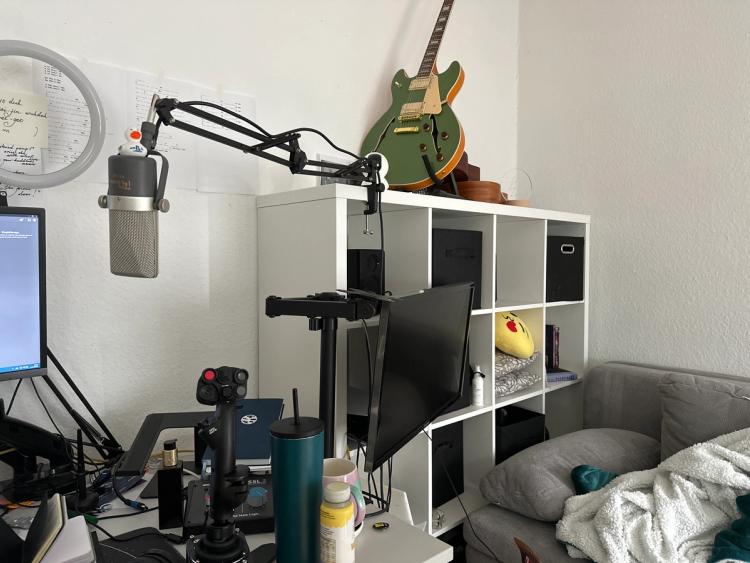 An intensely cluttered office displaying a variety of objects that don't seem to have anything to do with software engineering and three drinks, as I am a drink goblin