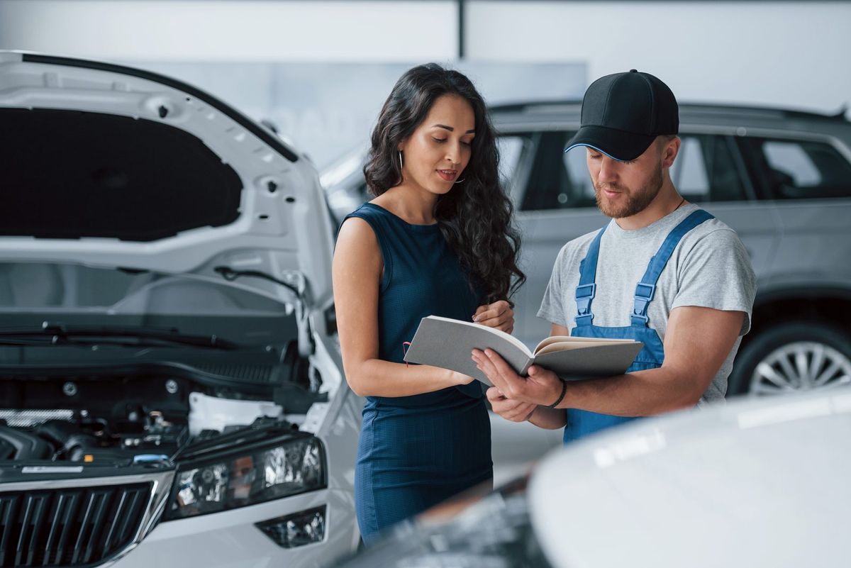Auto retailer advisor reviewing service details with a customer at a showroom