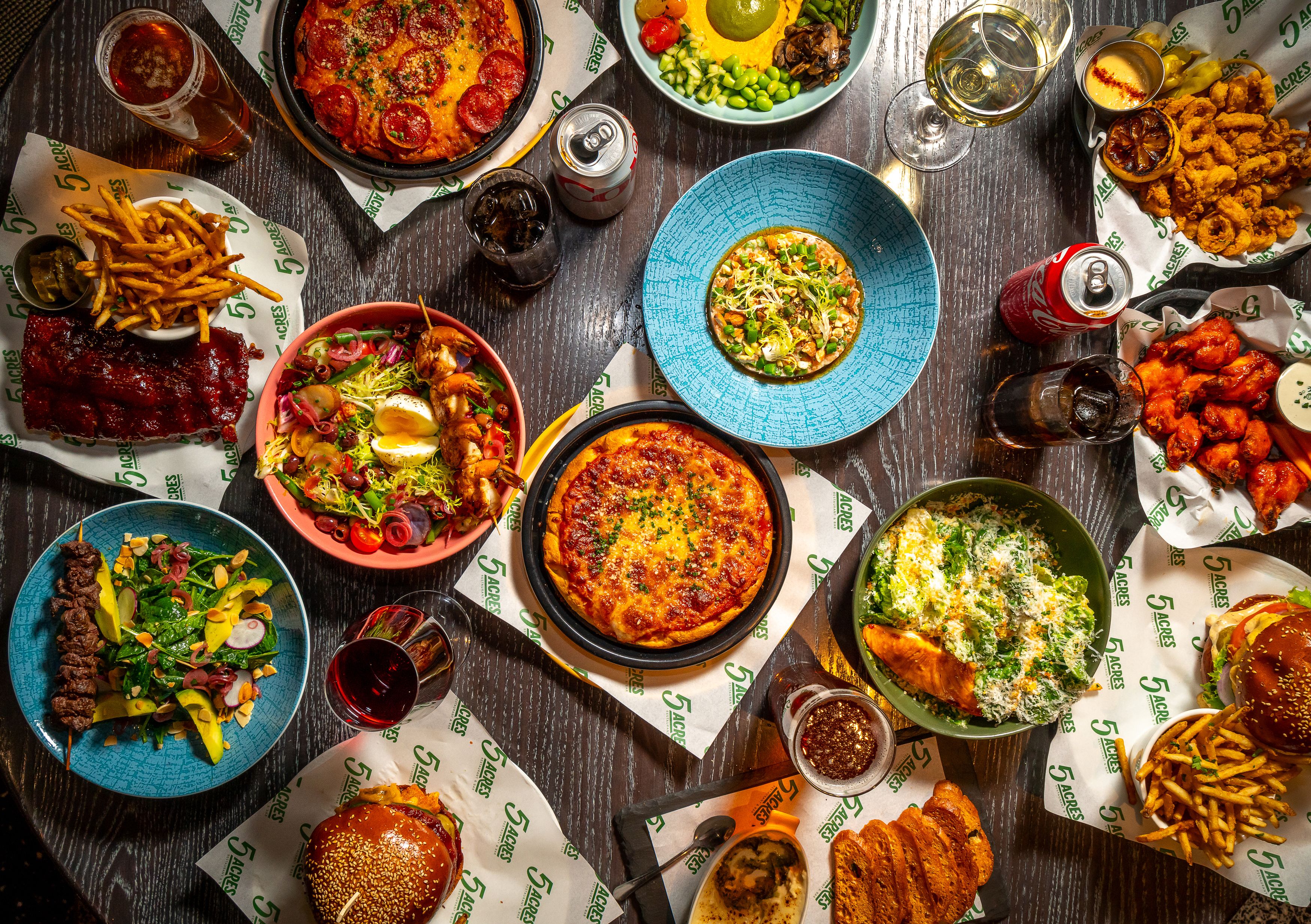 A spread of various brightly colored plates of food at 5 Acres Restaurant