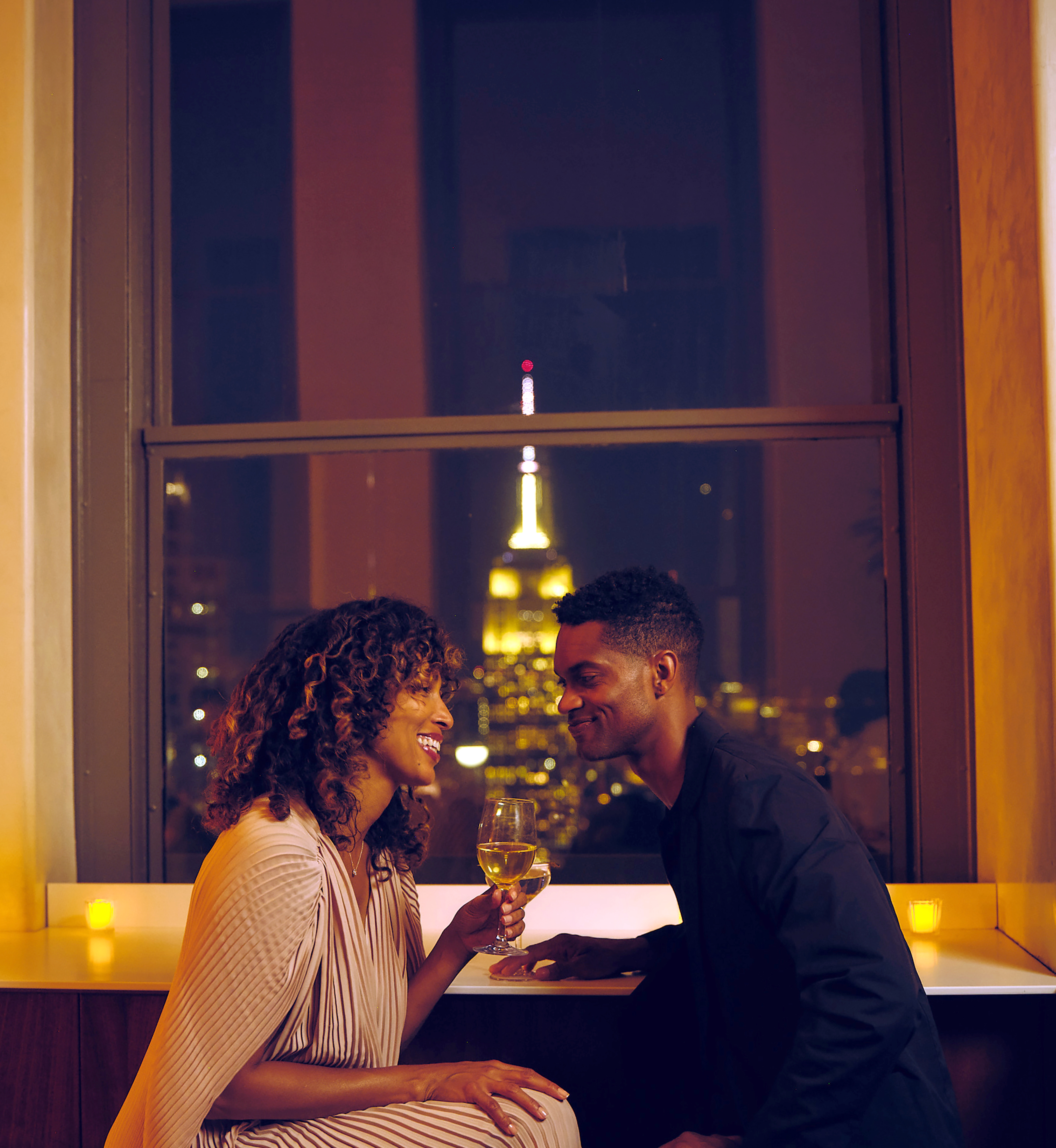 A couple sharing drinks at The Weather Room at Top of the Rock