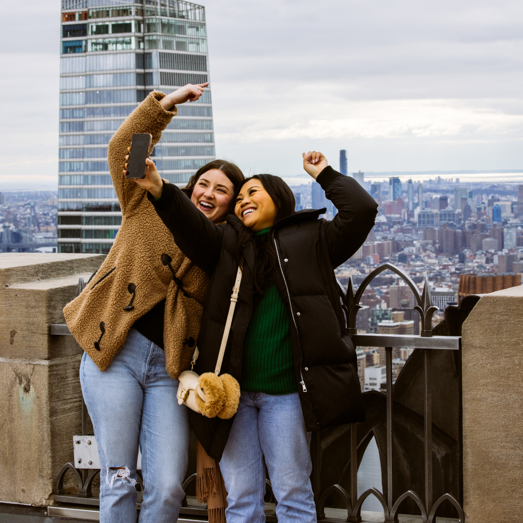 Two women posing for a photo at Top of the Rock at Rockefeller Center
