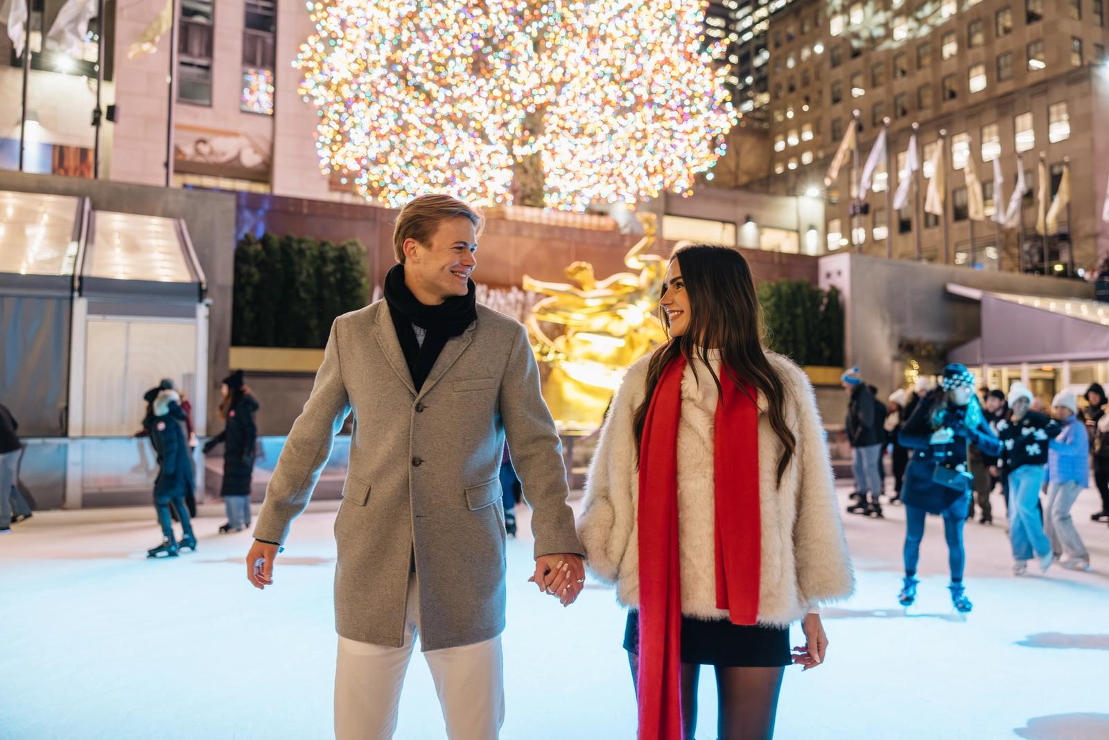 a man and woman holding hands skating together on the rink