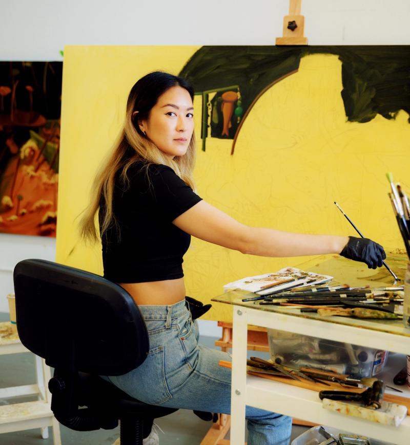Artist Dominique Fung painting in her studio