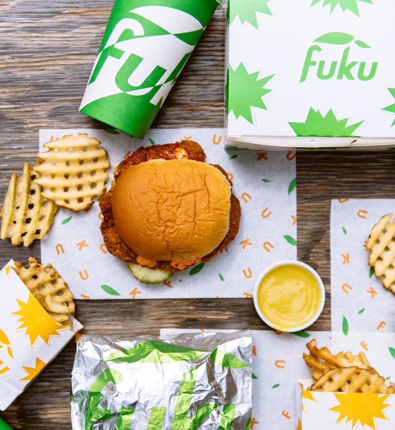 A chicken sandwich, fries, dipping sauce, and drink from Fuku