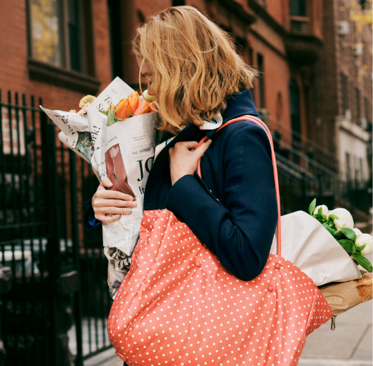 A woman holding a bouquet of flowers with a red polka dot purse
