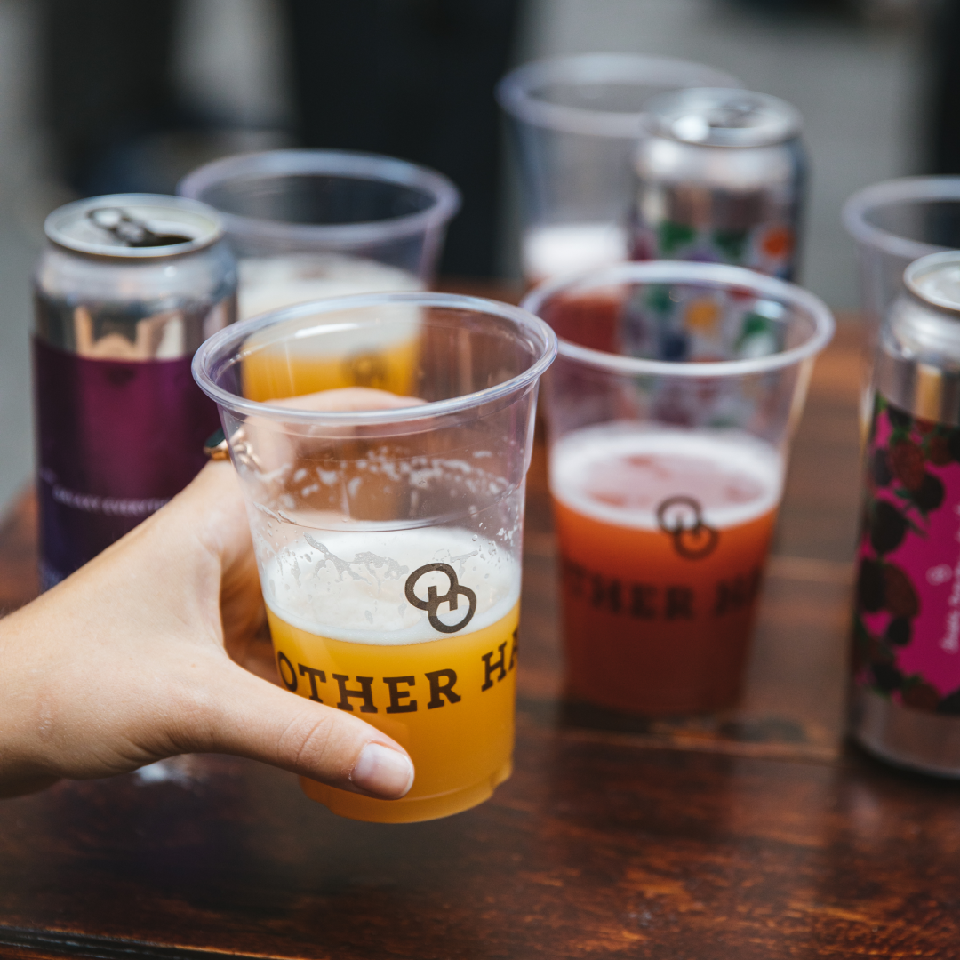 Hand holding a pint of beer from Other Half Brewing at Rockefeller Center