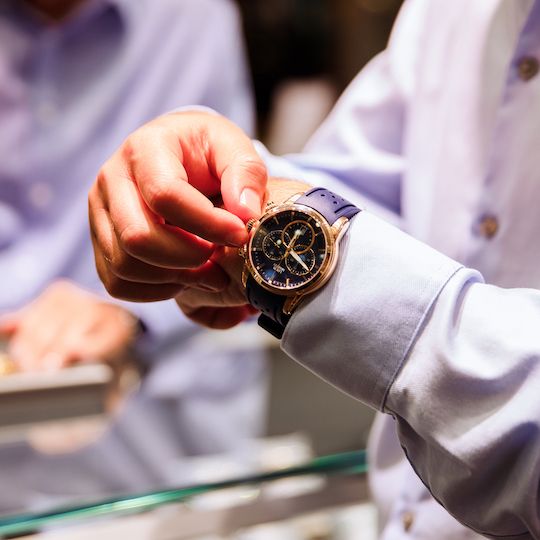 Person adjusting the time on a watch from Louis Martin at Rockefeller Center