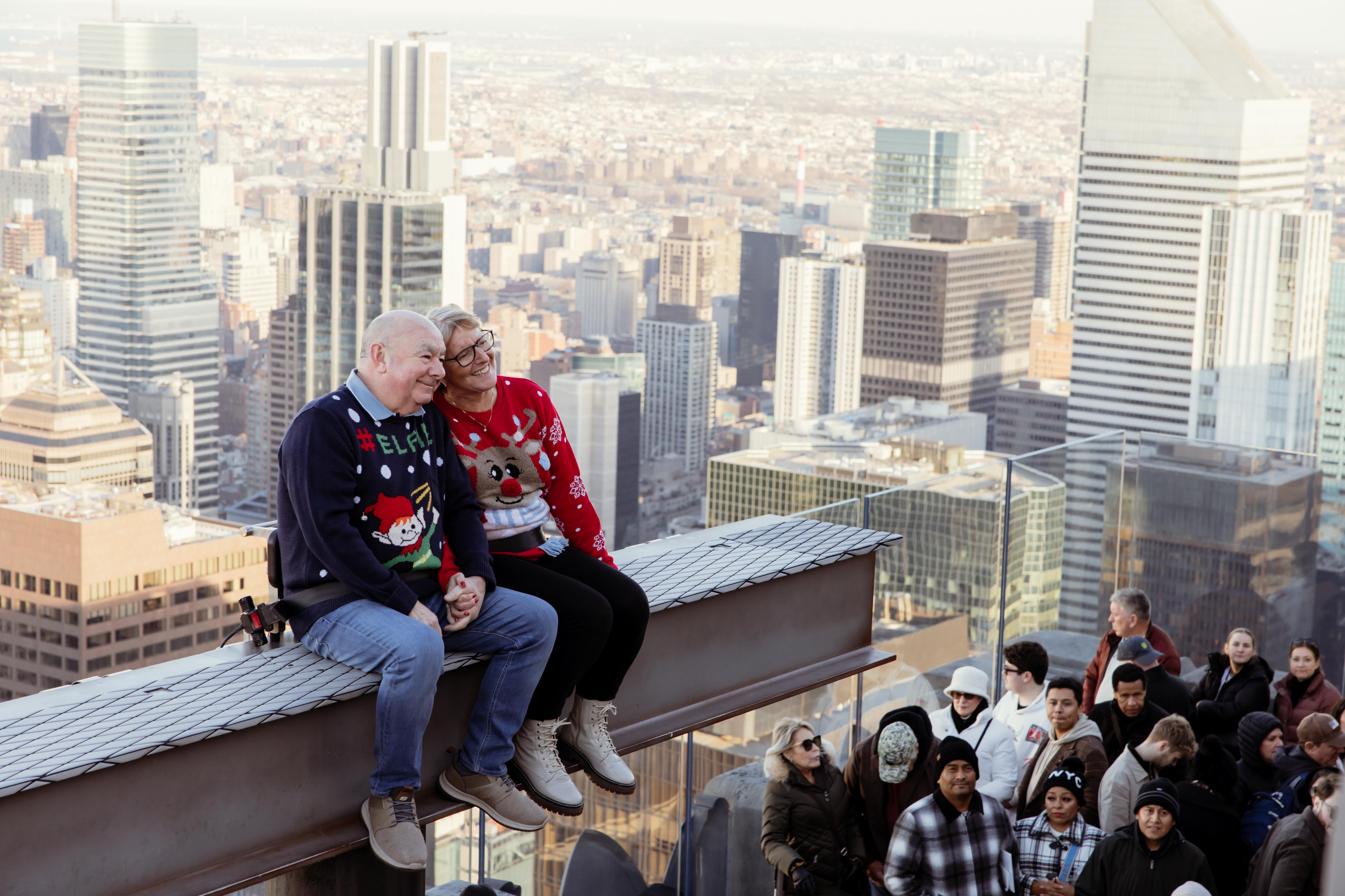a couple on the beam with Christmas Sweaters