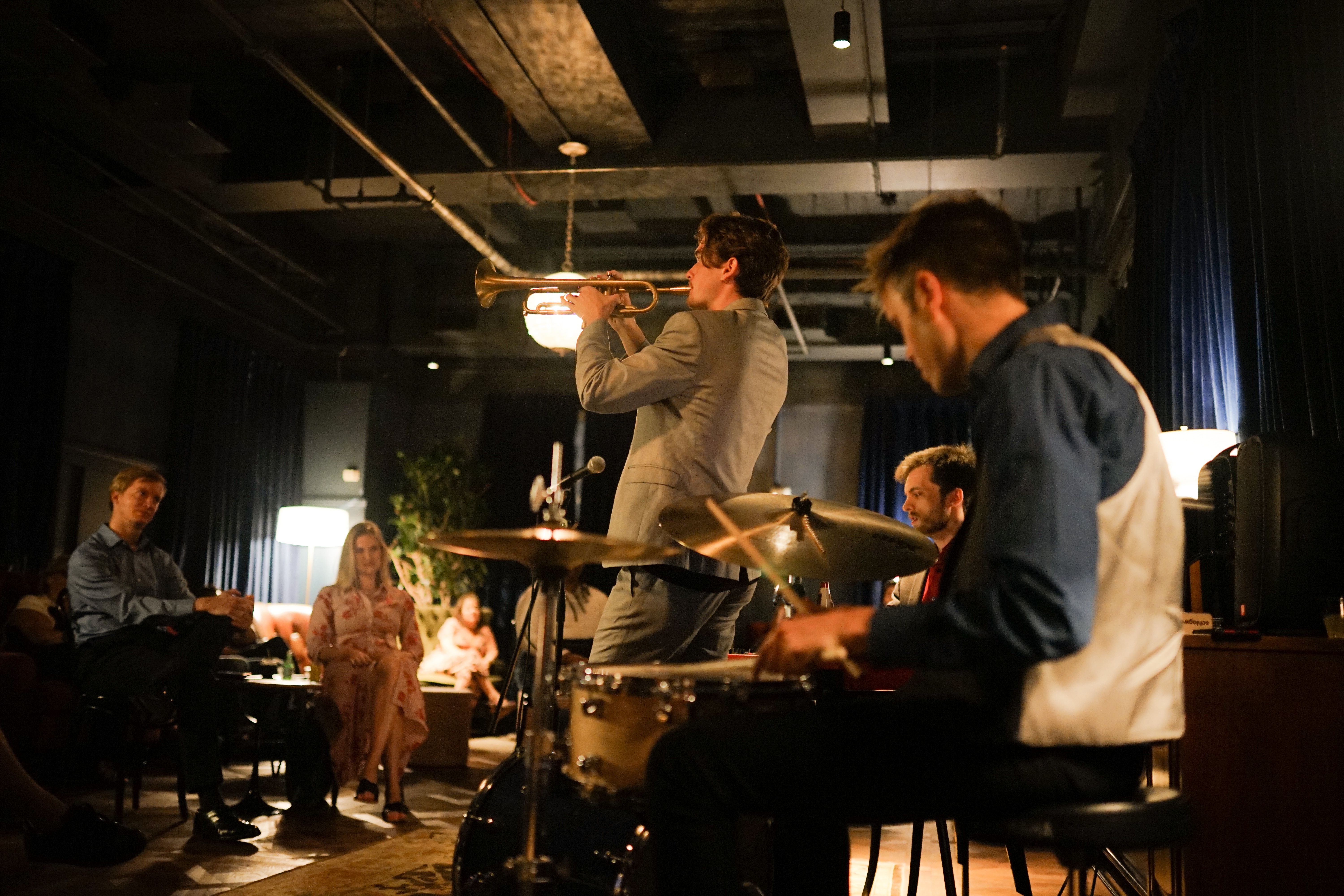 A band performs in front of a crowd at a small venue.