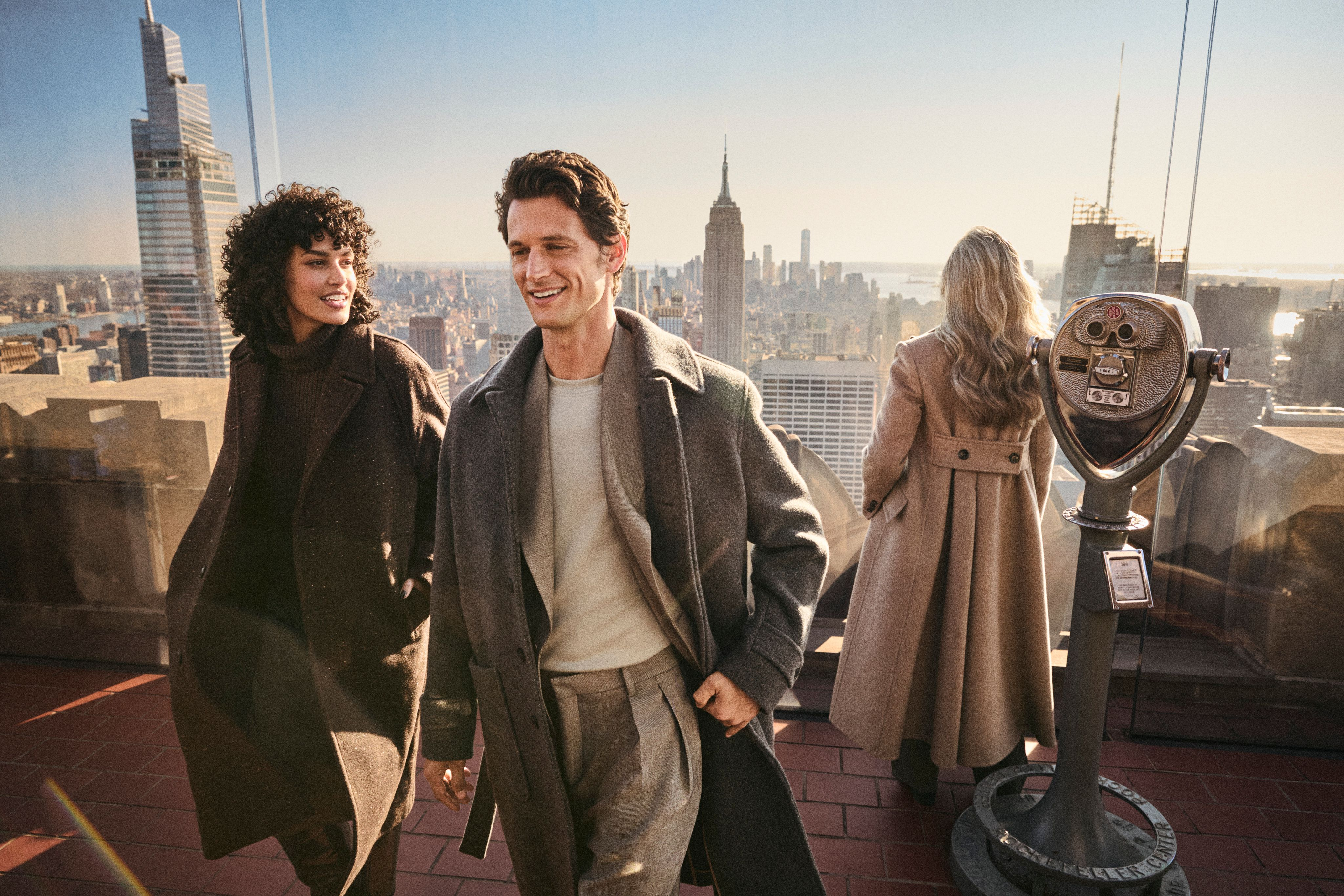three people smiling at top of the rock