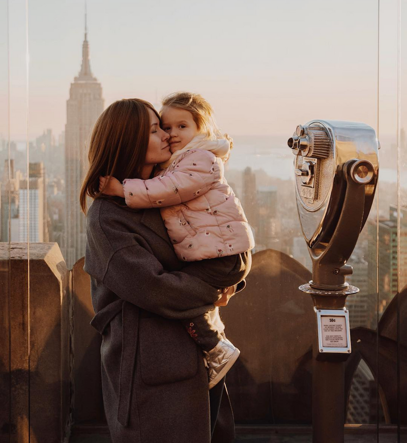 A mother holding her young daughter a Top of the Rock 