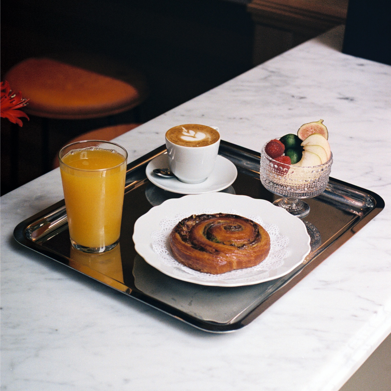 A tray featuring a cup of coffee, juice, and assorted breakfast items from Lodi at Rockefeller Center