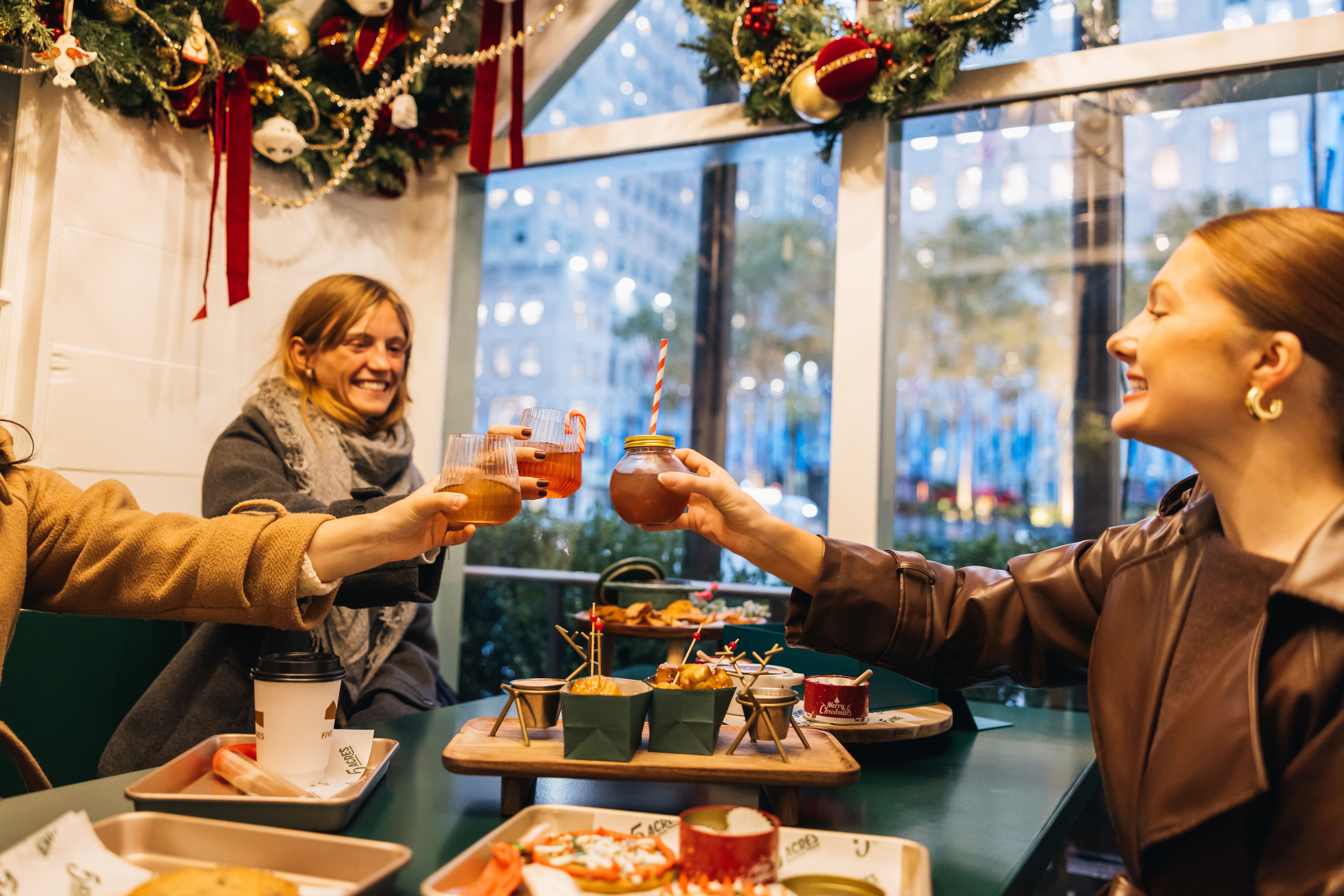 three people with drinks and food at the Apres Skate Chalets