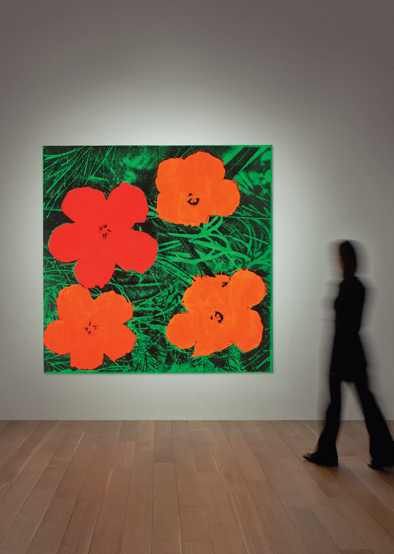 Person walking towards a painting of Warhol's Flowers hanging in a gallery