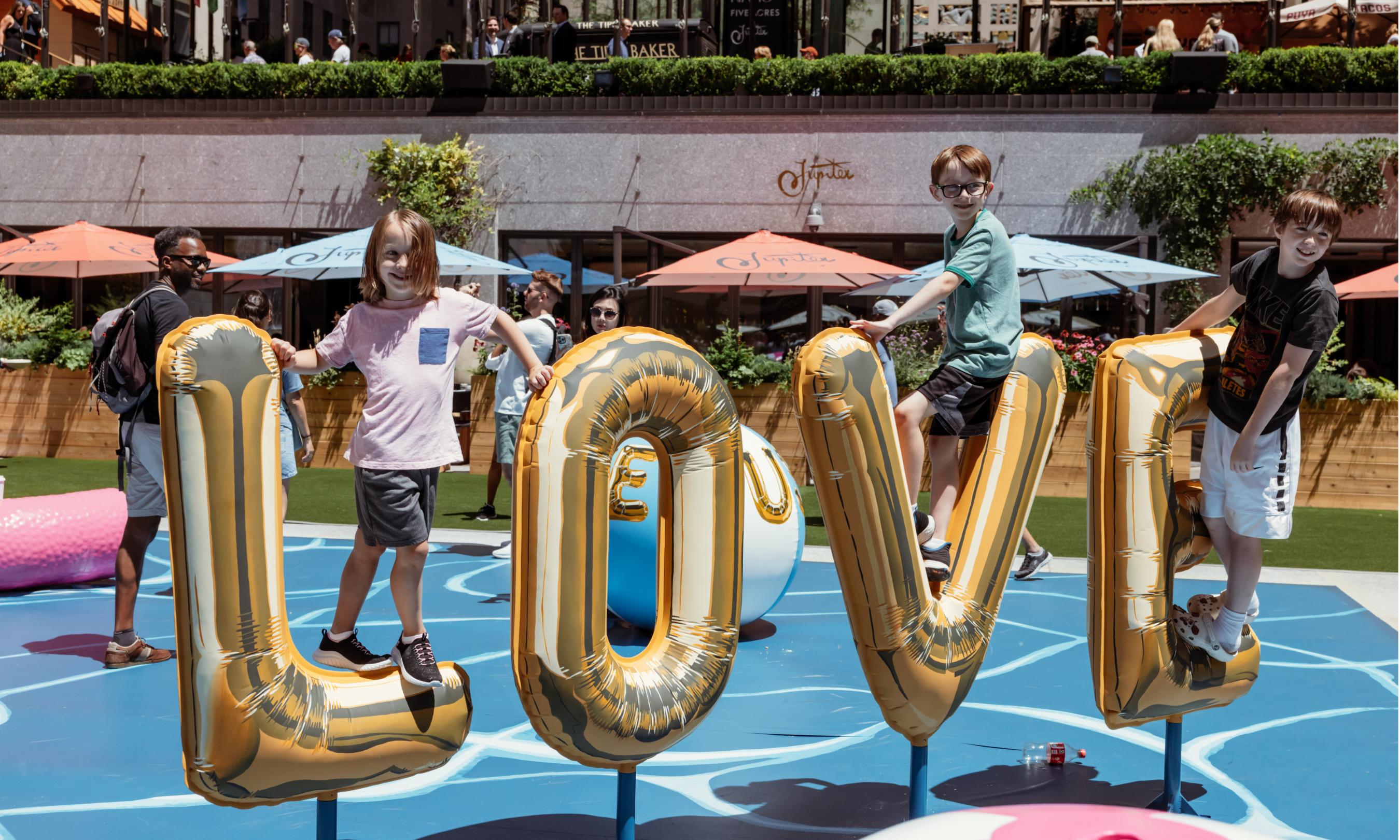 Three children climbing on an inflatable balloon sculpture