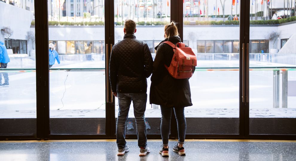 Couple stands in the Rink Level corridors at Rockefeller Center