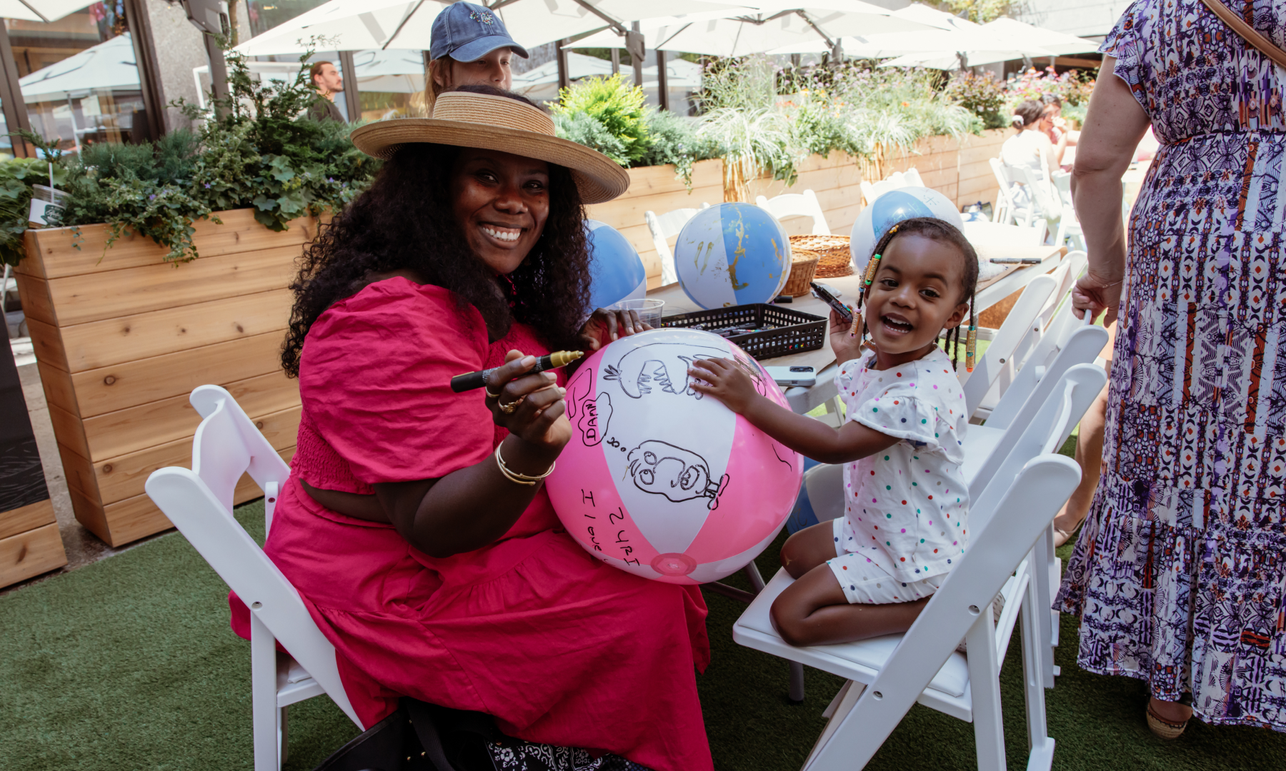 A parent and child decorating a beach ball as part of artist Joel Mesler's Art in Focus children's art workshop