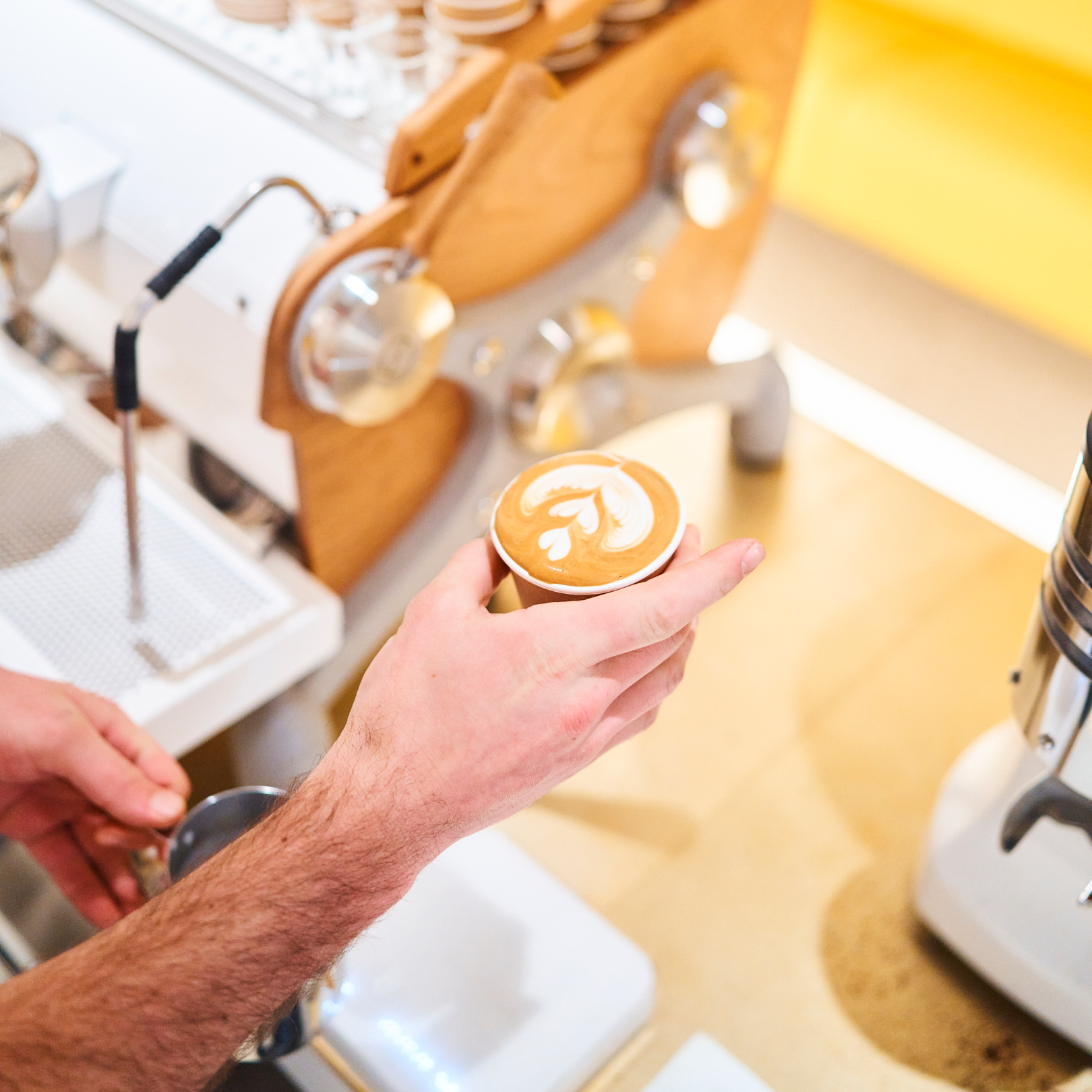 Hand holding a cup of coffee from % Arabica at Rockefeller Center