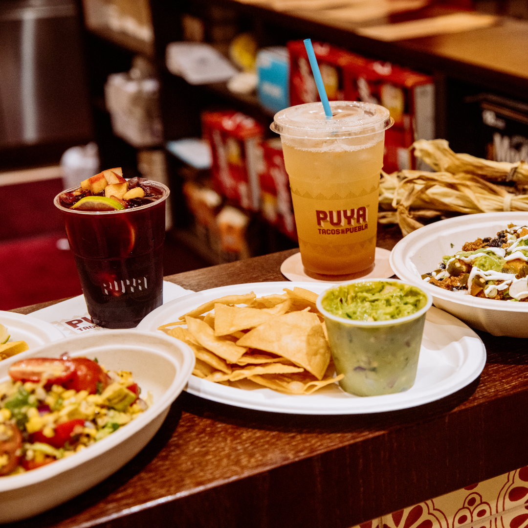Plates of food and two drinks from Puya Tacos at Rockefeller Center