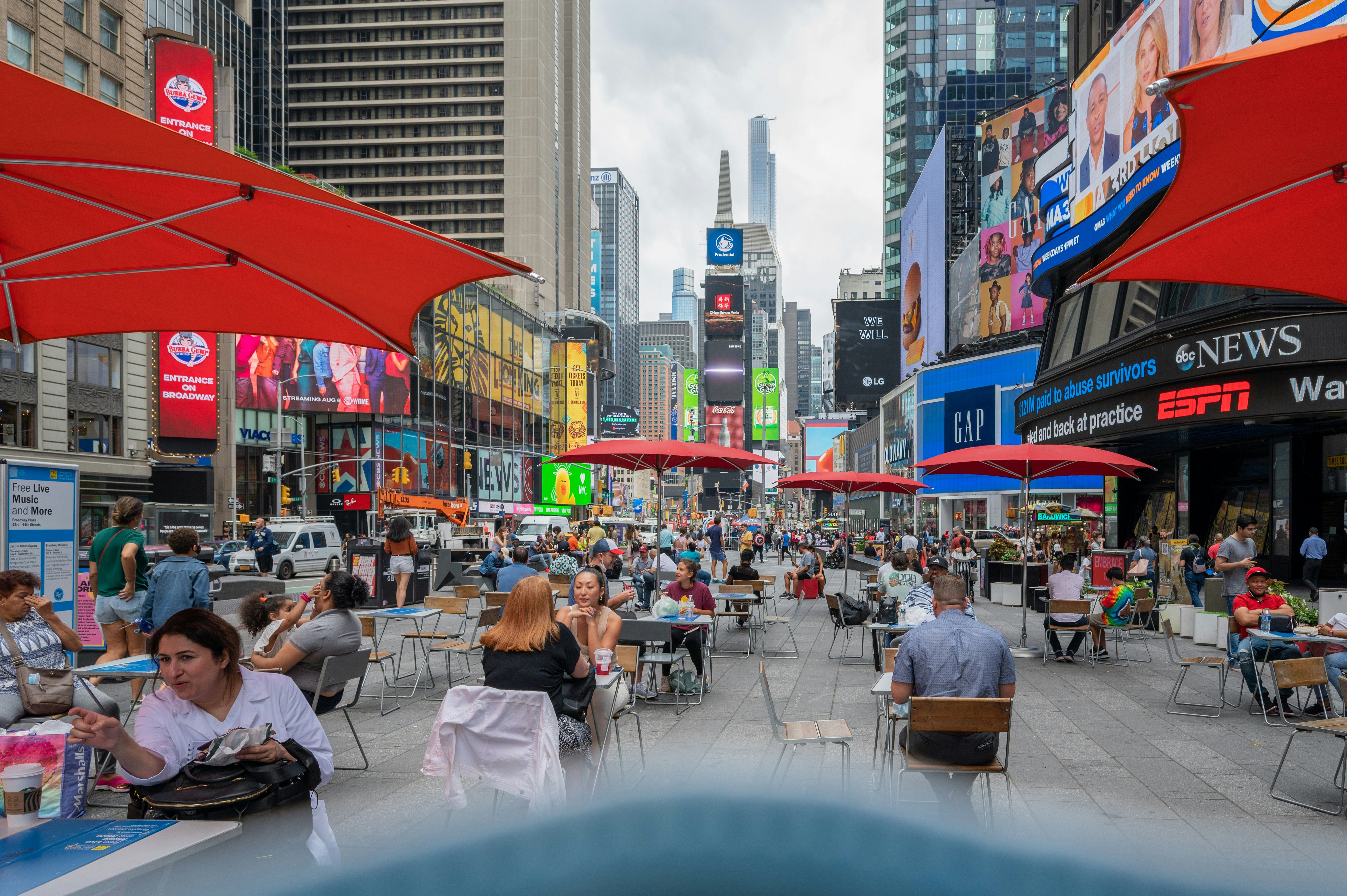 People sitting at tables in Times Square in a pedestrian zone