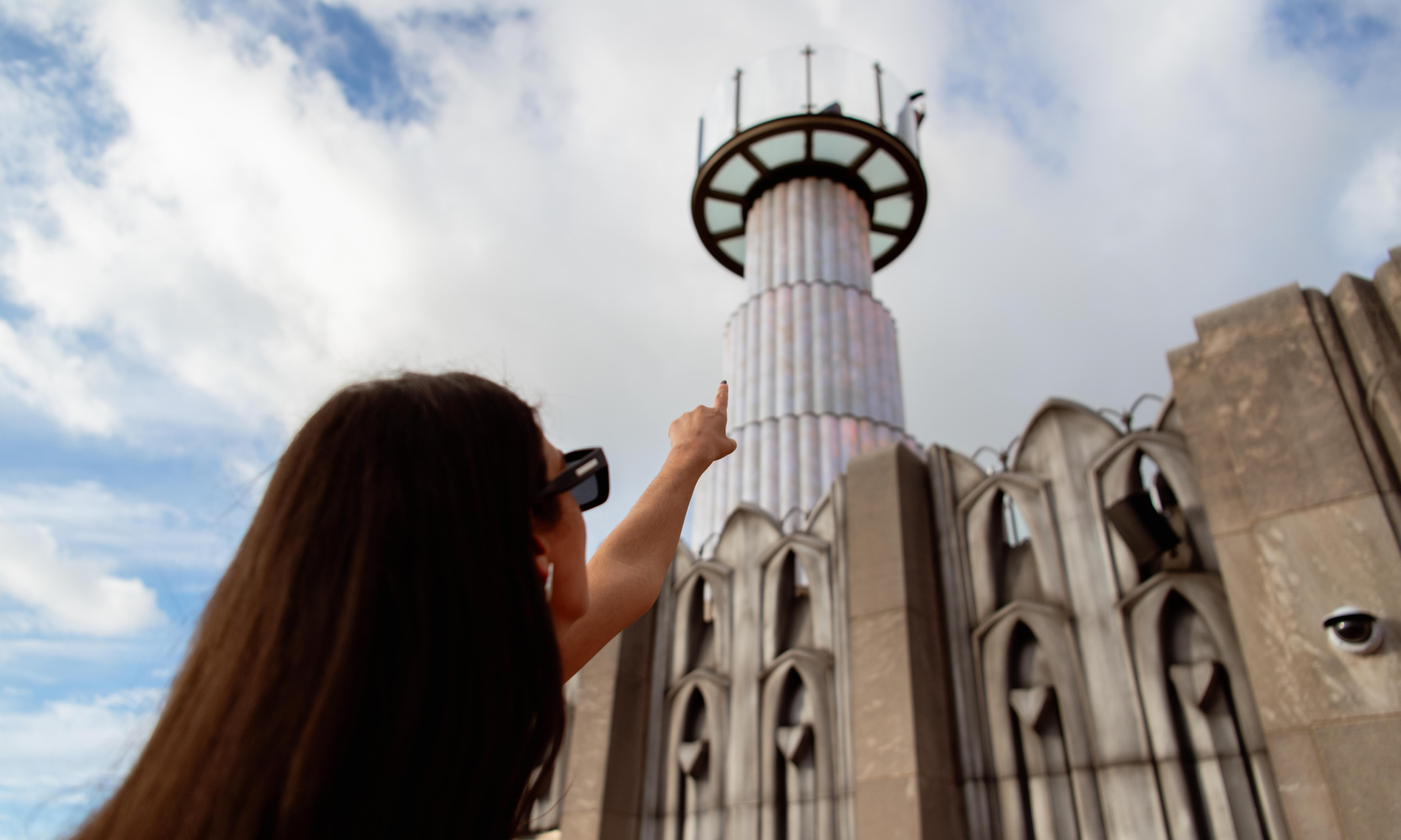 Person pointing at SKYLIFT from the rooftop of Top of the Rock