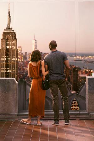 A couple embraces each other while watching a romantic sunset from Top of the Rock.