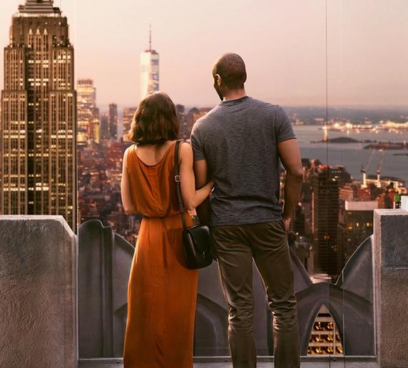 A couple embraces each other while watching a romantic sunset from Top of the Rock.