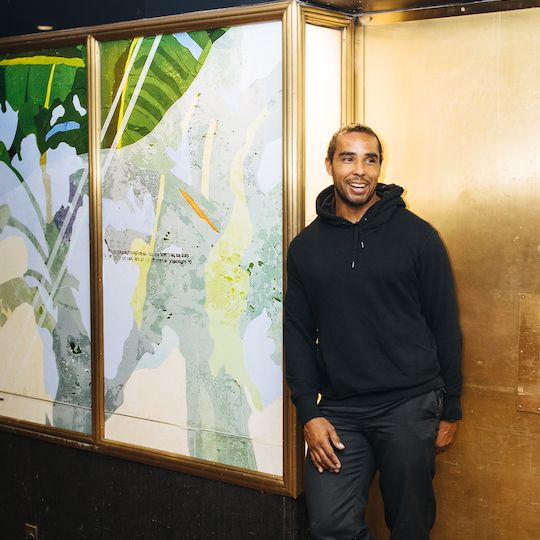 Artist Hugo McCloud stands in front of his artwork on display at Rockefeller Center