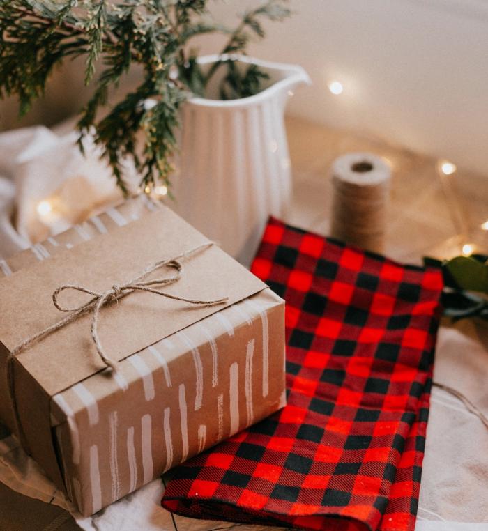 Present wrapped in brown paper next to red and black flannel cloth
