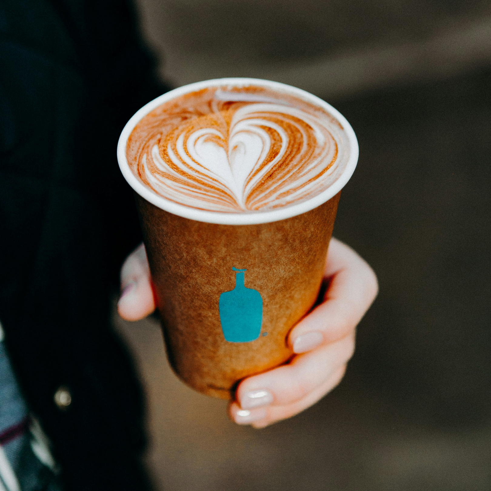 Hand holding a cup of coffee from Blue Bottle Coffee